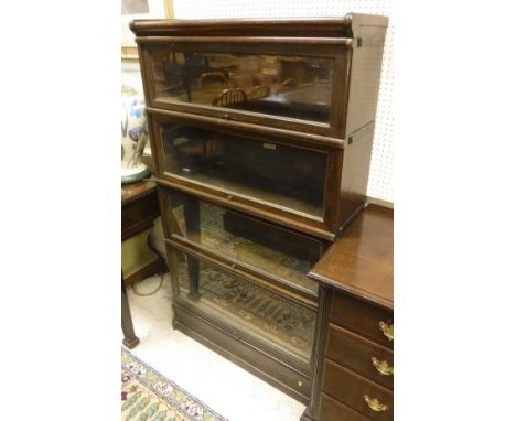 An oak four section Globe Wernicke bookcase with two ivorine labels to the back, one marked "D.T. Wright Cabinet Maker and Up