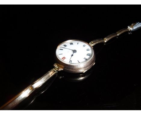 A 9ct gold cased ladies wrist watch, the white enamel dial set with roman numerals housed on an expandable 9ct gold bracelet 