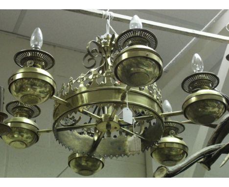 A modern brass electrolier in the Victorian gothic taste, the central castellated section holding six oil lamp style lights