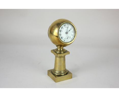A brass mantel clock, the eight day movement within a ball shaped case on pedestal, with secondary dial, 18cm high
