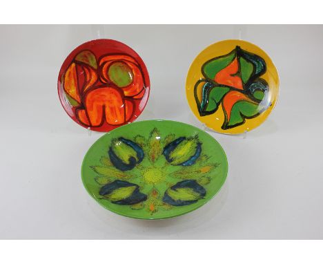Poole Pottery Delphis, including a green dish by Judi Evans, a yellow smaller dish by Anita Lawrence, and a red dish