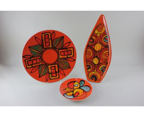Poole Pottery Delphis, including an arrow shaped dish by Carol Holden, a charger, and a small dish, all with abstract designs