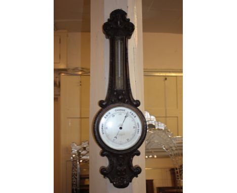 An early 20th century carved oak cased wheel barometer and thermometer, marked Short &amp; Mason Ltd, London 