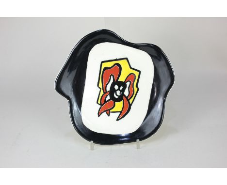 Roland Brice (1911-1989), a free form glazed earthenware plate inspired by Fernand Léger, with abstract decoration in red, ye