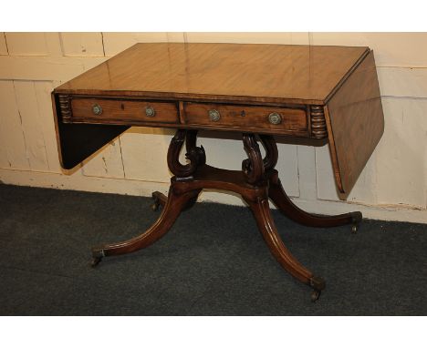 An early 19th century mahogany sofa table, rectangular top with drop end flaps, two drawers and opposing dummy drawers with b