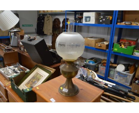 A brass oil lamp with etched glass shade