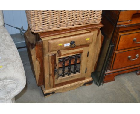 A hardwood cupboard with magazine rack and fitted single drawer