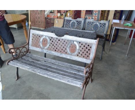 A wooden and metal garden table with matching pair of armchairs and bench