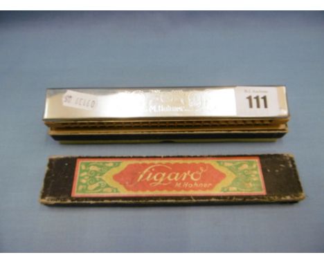 A cased M Hohner harmonica