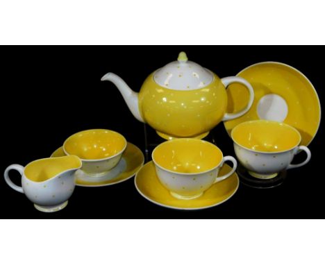 A Susie Cooper part tea service, decorated with yellow dots on a white ground, to include teapot, 15cm H, milk jug, cups, sau