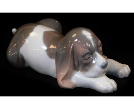 A Lladro figure of a sleeping Bassett hound, printed marks beneath, 6cm H.