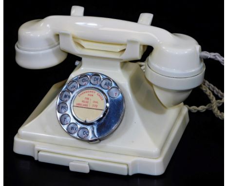 A vintage ivory coloured Bakelite telephone, with chrome plated front dial and drawer, rope attached receiver, 23cm W.