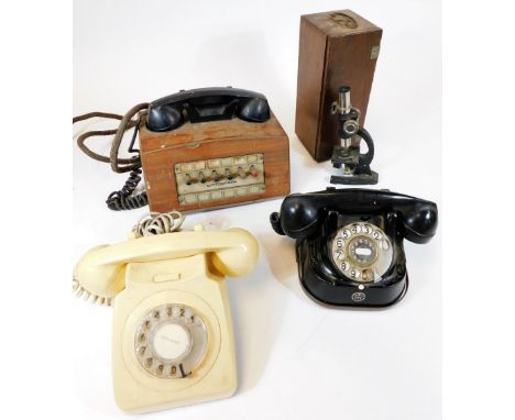 A vintage continental bell telephone, a white plastic telephone, a dictograph and a small microscope.  (AF)