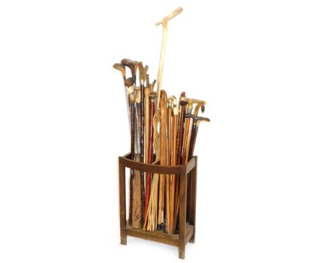 An oak stick stand, containing a quantity of various horn topped and other walking sticks, 92cm H, etc. shepherd's crook, hoc