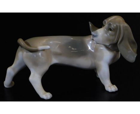 A Lladro figure of a Bassett hound, head turned, printed marks beneath, 12cm H.