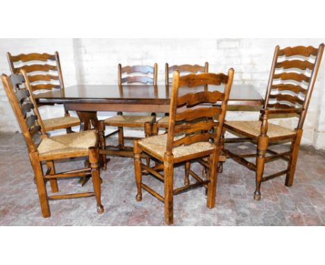 A Jacobean style oak dining suite, comprising of six ladder back chairs (4+2), each with rush style seats and turned legs and