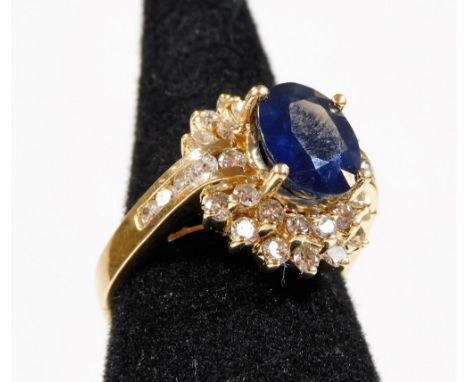 A sapphire and diamond dress ring, with central oval cut sapphire approx 2.69cts, in raised four claw setting, surrounded by 