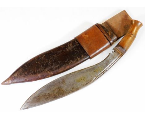 An early 20thC kukri, with shaped blade, leather scabbard and turned wooden handle, 51cm W.