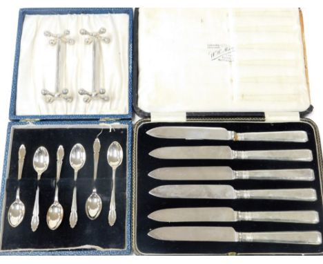 A pair of six silver handled tea knives, in case, a set of six George V silver coffee spoons, Sheffield 1934, in case, pair o