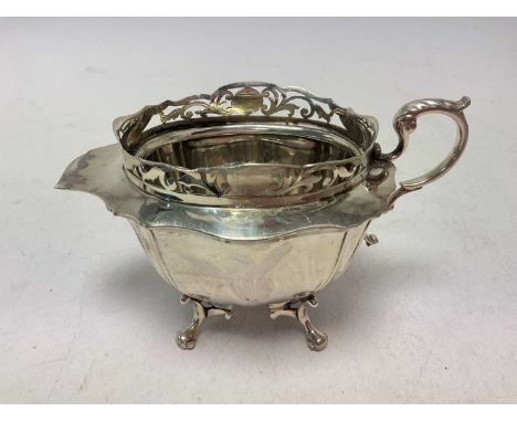 Unusual silver jug with pierced border and four feet (Sheffield 1911) 15.5cm handle to spout

Weight 7 Troy oz.