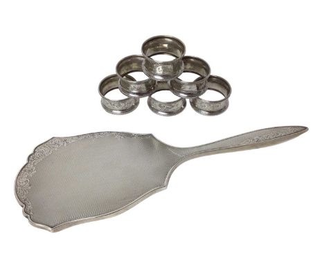 Silver back hand mirror with engraved floral scroll decoration together with set of six silver napkin rings (Birmingham 1923-