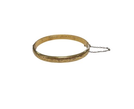 9ct gold hinged bangle with engraved scroll decoration (Chester 1953). Approximatley 17.5cm inner diamater Weight 8.9 grams
