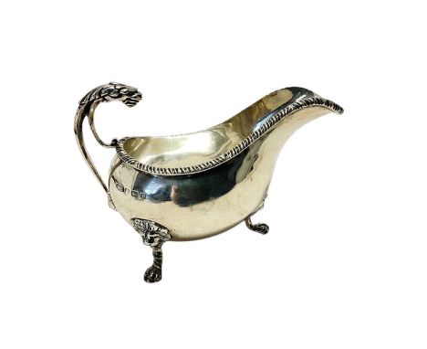 George V silver sauce boat with gadrooned border and lion mask handle, raised on three paw feet, (Birmingham 1914), maker Jam