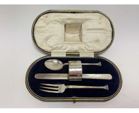 Art Deco silver christening set comprising of knife with mother of pearl handle, fork, spoon (all Sheffield 1922) and a napki