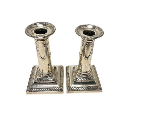 Pair late Victorian silver candlesticks, with plain columns and swag decoration, on weighted, fish scale decorated bases, sep