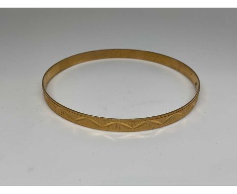 18ct gold bangle with engraved geometric decorationWeighs 13.7g.
