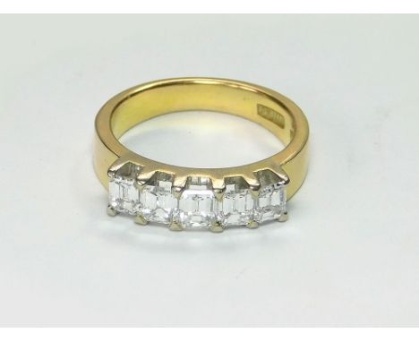 DIAMOND RING. A hand made yellow metal (assessed as gold), five stone, emerald-cut diamond ring, with stamped marks. Size K/L