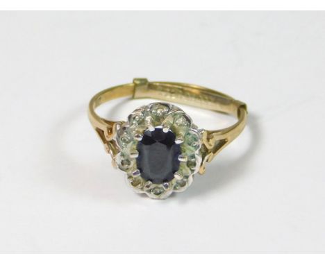 GOLD RING. A 9ct. gold, sapphire cluster ring, with illusion-set small, clear chips. Condition Report: Good, pre-owned condit