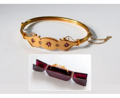 VICTORIAN BANGLE. A late 19th century, 9ct. gold hinged bangle, set with rubies & diamond chips. Fitted bangle box. Approx. 6