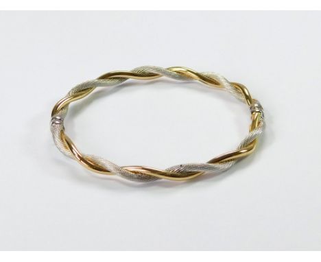 GOLD BANGLE. An Italian, modern 9ct. yellow gold & white gold twist, hinged bangle. Internal width, 6.1cm. Approx. 5.1g. Cond