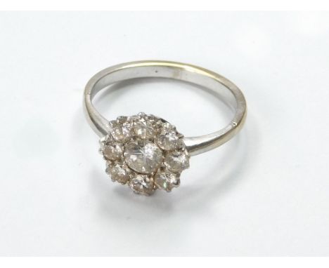 DIAMOND RING. A diamond flowerhead cluster ring, set in unstamped white metal, possibly platinum. Central diamond approx. 0.4