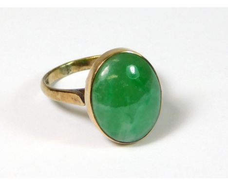 JADE RING. A South East Asian 14k. jade-set dress ring. Size L. Approx. 4.2g. Condition Report: Very good. The domed stone me