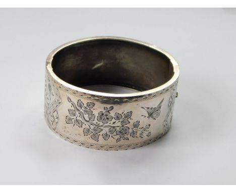VICTORIAN BANGLE. A Victorian, broad cuff bangle in engraved silver coloured metal. Condition Report: Shallow dent on plain r