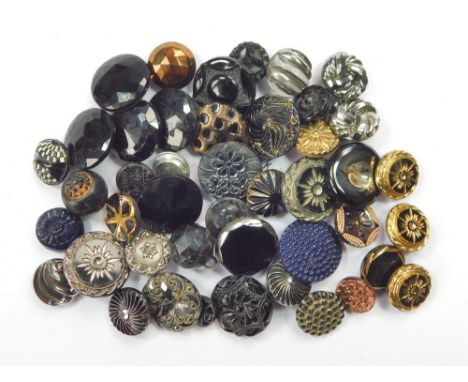 BUTTONS. Various black buttons, mostly moulded glass, some with gold, bronze or silvered decoration. Largest, 1.6cm. Conditio