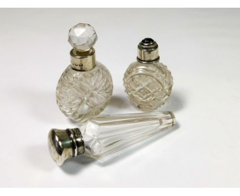 PERFUME BOTTLES. Two silver mounted perfume bottles; an Edwardian faceted flask & a late Victorian cut glass bottle & stopper