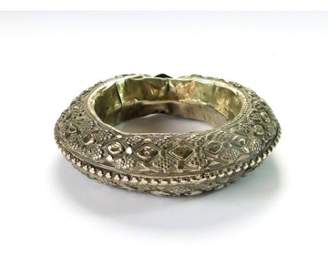 ANKLE BRACELET. An Indian silver-coloured metal, ornate anklet, probably a dowry item. External diameter, 11cm. Internal diam