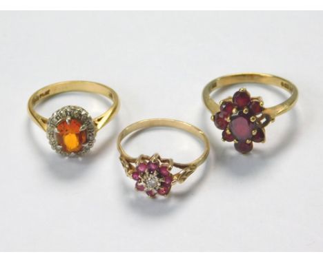 GOLD RINGS. An 18ct. gold, citrine & diamond cluster dress ring, a 9ct. gold ruby & diamond flowerhead ring & a garnet-set, 9