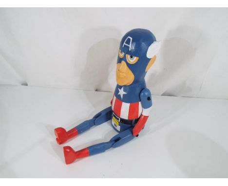 A good quality carved wooden shelf puppet depicting Captain America. Estimate £20 - £30