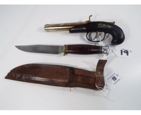 A late 20th century petrol lighter in the form of a percussion pistol and a camping /scouting knife with a 13cm blade