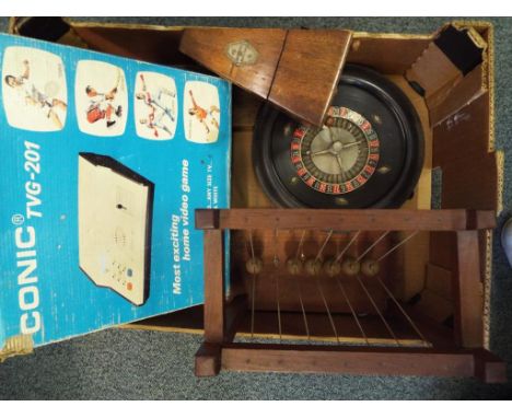 A good lot to include a Conic TVG-201 vintage home video game system, a roulette wheel, a vintage metronome, a cased set of b