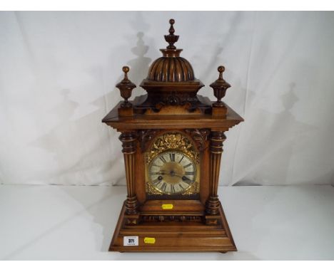 A walnut cased bracket clock with decorative brass metal face. Estimate £80 - £120