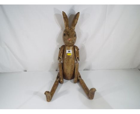 A carved wooden shelf rabbit with jointed limbs Est £20 - £40