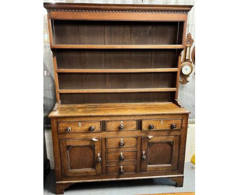 Early 19th century North Wales oak two stage dresser, the moulded top with three shelf boarded rack, the projecting base with