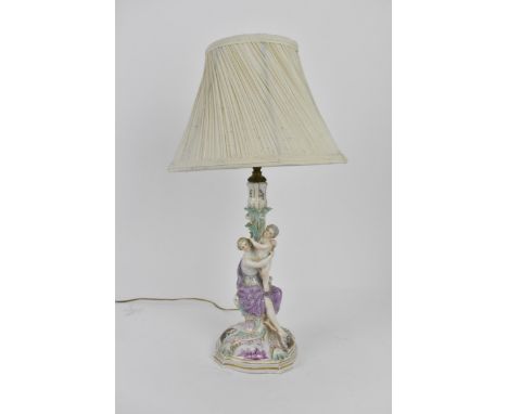 A German porcelain figural candlestick converted as a lamp, the column with classical lady supporting a child holding a folia