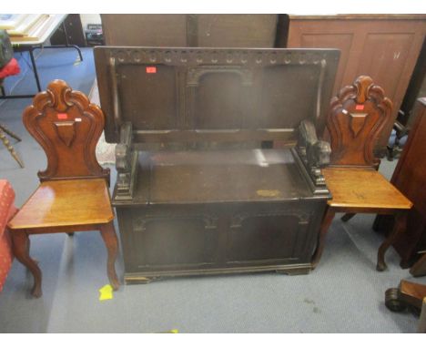 Two Victorian oak hall chairs with carved backs on French cabriole front legs, and a mid-century dark oak carved monks bench 