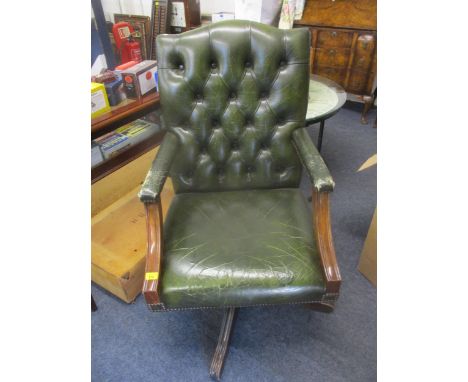 A 20th century mahogany leather button back upholstered swivel desk chair, upholstered in green leather with brass stud workL